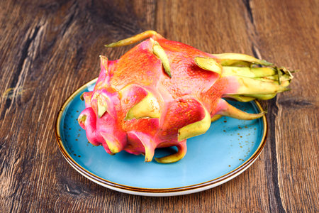 Whole and ripe unpeeled pitahaya on a plate. Copy space.の写真素材