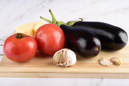 Vegetables and cheese on a wooden cutting board. Healthy food.の写真素材
