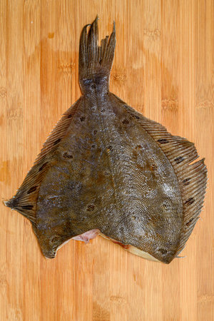 Defrosted flounder on a wooden cutting board.