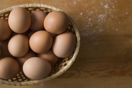 Brown eggs in a basket on a tableの写真素材