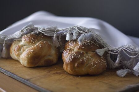 Two covered challah for Shabbat on a wooden tableの写真素材
