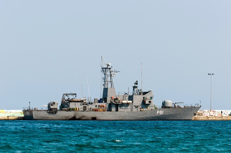 Big battle ship in the dock against blue sky and mountainsのeditorial素材