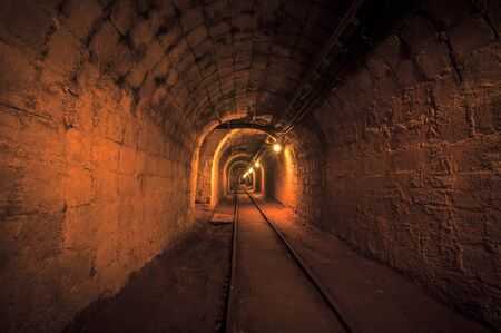 Underground mine passage with rails and lightのeditorial素材