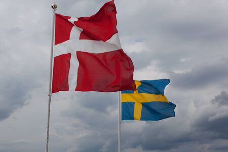 The Danish and Swedish flag waving in the windの写真素材
