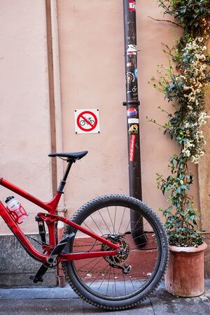 A bicycle leaning against a wall with bicycle prohibition signsの写真素材