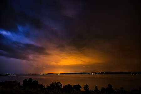 A thunderstorm over the Bodensee provides for a beautiful playの写真素材