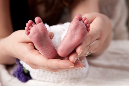Feet of a newborn Baby in the Hands of her Motherの写真素材