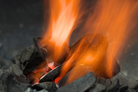 Burning charcoal with orange-colored flame and glow (Selective Focus, Focus on the front of the...