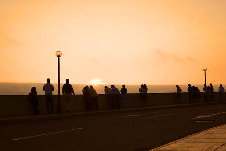 LIMA, PERU - MARCH 11, 2012  Unidentified people watching the sunset over the Pacific ocean from the pavement along the Malecon de la Reserva in Miraflores on March 11, 2012 in Lima, Peru  のeditorial素材