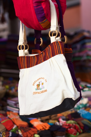 COPACABANA, BOLIVIA - OCTOBER 23, 2014: A handbag with the writing Recuerdo de Copacabana (Souvenir from Copacabana) hanging at a souvenir and handicraft stand in the small tourist town on the shore of the Titicaca Lake on October 23, 2014 in Copacabana, のeditorial素材
