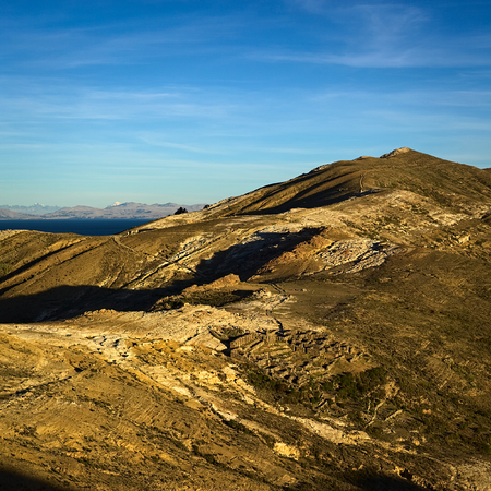 The Northern part of Isla del Sol (Island of the Sun), a popular tourist destination in Lake Titicaca, Bolivia shortly before sunset. In the lower part the Tiwanaku-Inca ruin Chinkana is visible.の写真素材