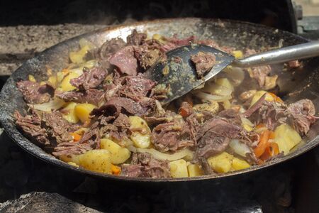 Veal with vegetables in a wÐ¾k cooked on a fire in a mobile kitchen.の写真素材