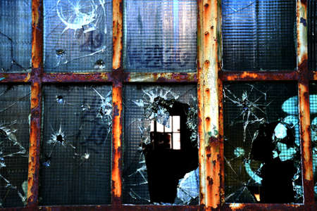 bullet hole in glass - authentic gunshot - on old industrial window lostplaceの写真素材