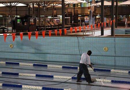 Worker cleans the hotel poolの写真素材
