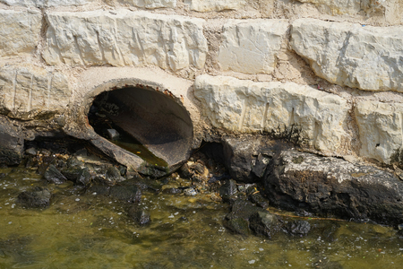 Drainage pipe in sea water on the baechの写真素材