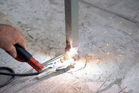 welder working with electrode outdoors