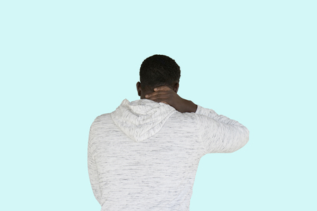 Neck hurt concept with african american man holding his neck from the back isolated on a white backgroundの写真素材
