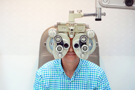 Man ophthalmologist examining patient man with optometrist trial frame. Male patient to check vision in ophthalmological clinicの写真素材