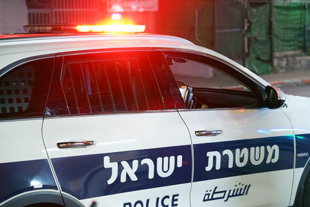 Israeli police car. The inscription on the door of the car is in Hebrew and in Arabic. Close-up of the red lights on top of a Israeli police vehicle.のeditorial素材