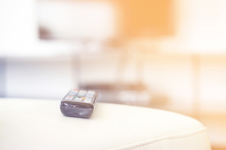 TV remote control on couch indoors, closeup. Home cinema