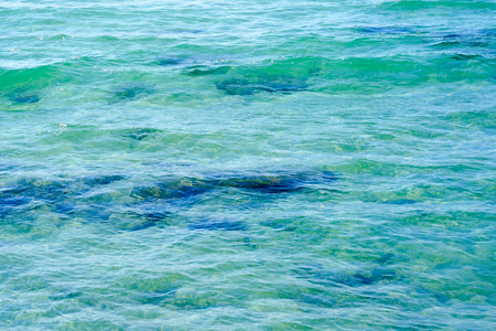 Clear water background, blue natural texture. Sea wave close up, low angle view.の写真素材