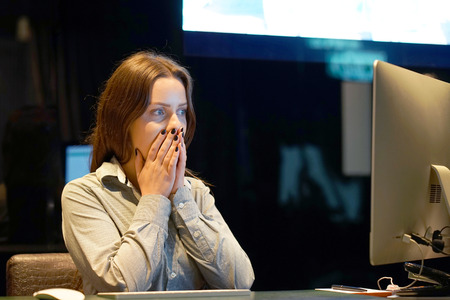 Hotel manager. A woman-reception shocked sitting in front of the monitor of computer. Funny face expression emotion feelings problem perception reaction, stress, fearの写真素材
