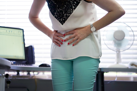 Close-up office worker Woman having painful stomachache. Chronic gastritis. Body And Health Care Concept.の写真素材