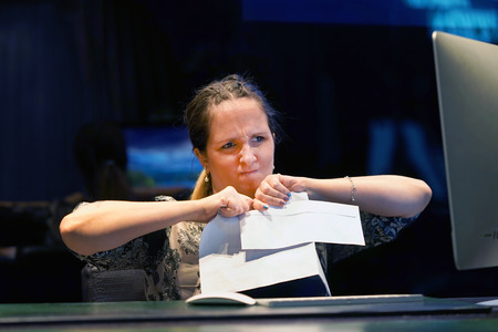 A woman-reception hotel worker tear the letter negative news. Shocked beauty girl business manager received layoff message letter from company feeling surprised. An agitated girl without joy.の写真素材