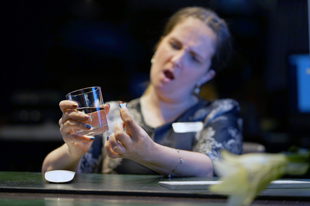 Hotel administrator. Sick woman-reception worker holding pill glass of water. Depressed unhealthy woman, about to take antidepressant pill, emergency contraceptive, painkiller for painful periods.の写真素材