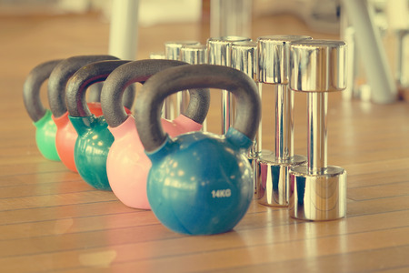 Colorful kettlebells in a row in a gym. Toning