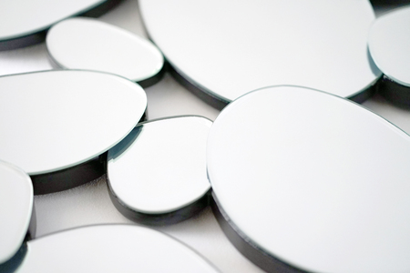 Mirror with ellipse, oval in wall, decoration and reflection. Abstract glass background. Polygonal surface. Close-up. Texture.の写真素材