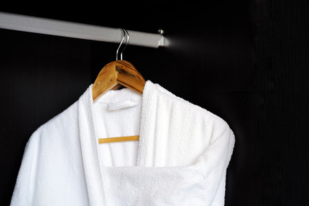 Two white coats hanging on the door. Hotel dressing gowns on the door hanger.の写真素材