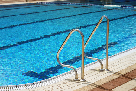 Handrails for descent into the pool. Pool cleaner during his workの写真素材