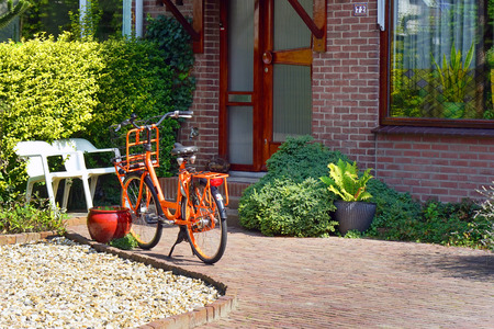 Orange bicycle near a private houseの写真素材