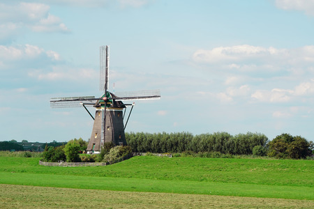 Old windmill against the blue sky in the morning in the summer. An old white mill. Fragment.の写真素材