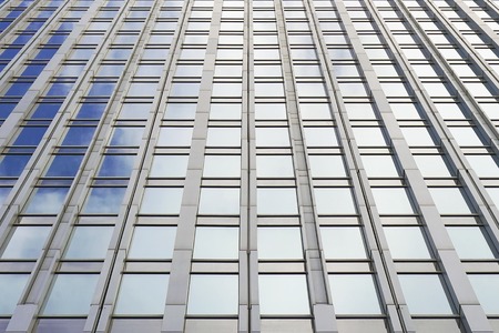 Bottom view glass grey square Windows of modern city business building skyscraper.