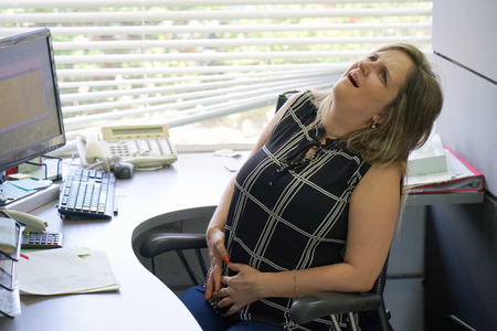 Close-up office worker Woman having painful stomachache. Chronic gastritis. Body And Health Care Concept.の写真素材