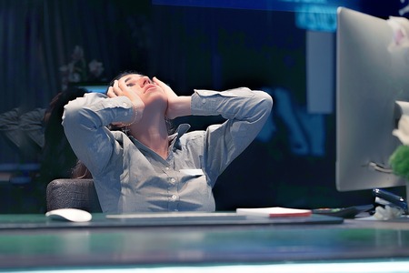 Hotel manager. A woman-reception shocked sitting in front of the monitor of computer. Emotion feelings problem perception reaction, stress, fear. Woman in stress in front of computer.の写真素材