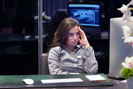 Hotel manager. A woman-reception shocked sitting in front of the monitor of computer. Emotion feelings problem perception reaction, stress, fear. Woman in stress in front of computer.の写真素材