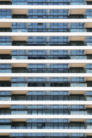 Glass grey square Windows of modern city business building skyscraper. Glass balconies in the building. Modern apartment buildings in new neighborhood. Windows of a building, texture.の写真素材
