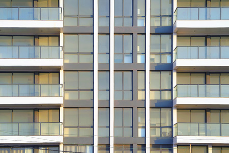 Glass grey square Windows of modern city business building skyscraper. Glass balconies in the building. Modern apartment buildings in new neighborhood. Windows of a building, texture.の写真素材