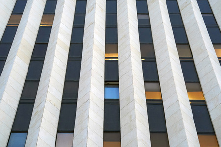 Bottom view glass grey square Windows of modern city business building skyscraper. Receding perspective, movement forward and up. Bottom view of office building window close up.の写真素材