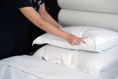 Maid making bed in hotel room. Housekeeper Making Bedの写真素材