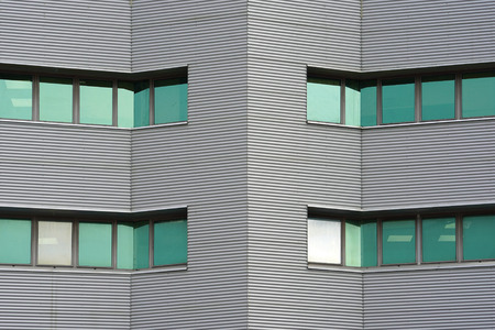 Green windows of modern city business building skyscraper. Modern apartment buildings in new neighborhood. Windows of a building, texture.の写真素材