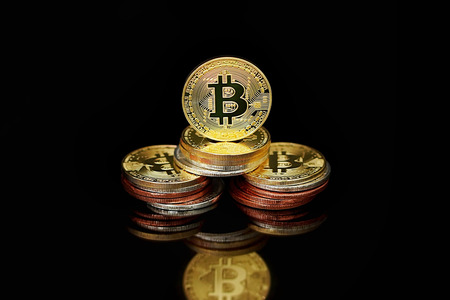 Close-up virtual currency bitcoin on black background. Golden, silver, bronze, bitcoins on black...