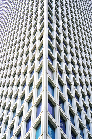 Angle modern business building skyscraper glass and aluminum, white square. Windows of facade. Modern apartment buildings in new neighborhood. Windows of a building, texture.の写真素材
