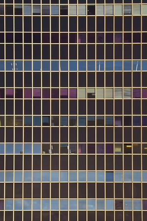 Glass blue square Windows of facade modern city business building skyscraper. Modern apartment buildings in new neighborhood. Windows of a building, texture.の写真素材