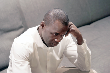 Loss of a loved one. Grief in the family. Death of a child. Sad face depressed african man. Very sad man. Concept of loneliness and pain.の写真素材