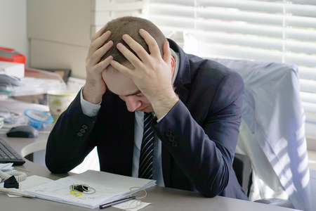 Close-up of office worker is distressed with a lot of paperwork. Stressed office worker. A lot of paper work. Job, occupation and overworking concept.の写真素材