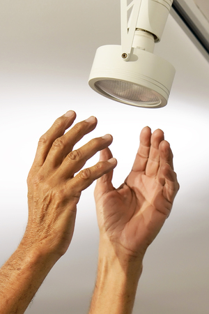 Electric male hand lamps with ceiling LED lamp, spotlight. The concept of repair and maintenance.の写真素材